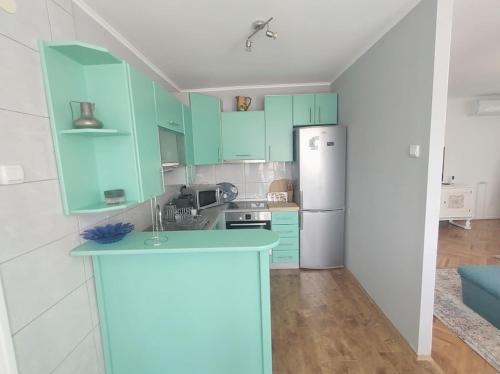 a kitchen with mint green cabinets and a refrigerator at Apartman Centar in Pirot