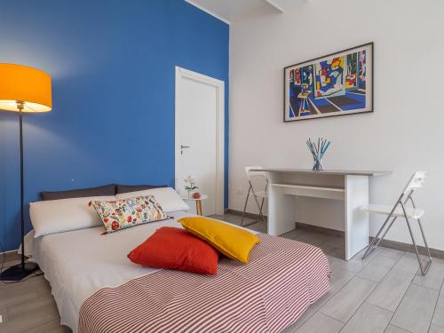 a bedroom with a bed and a desk and a table at Loveflat - scopri Ferrara in bicicletta in Ferrara