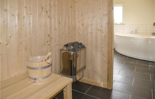 baño de madera con bañera y cubo de basura en Pet Friendly Home In Skjern With Kitchen, en Stavning