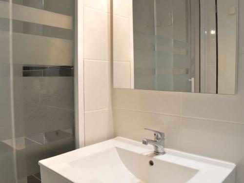 La salle de bains blanche est pourvue d'un lavabo et d'un miroir. dans l'établissement Maison Fleury-Saint-Pierre-la-Mer, 1 pièce, 4 personnes - FR-1-229D-309, à Saint Pierre La Mer