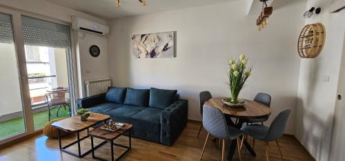 ein Wohnzimmer mit einer blauen Couch und einem Tisch in der Unterkunft Kraljevački Lux parking GARAŽA in Kraljevo
