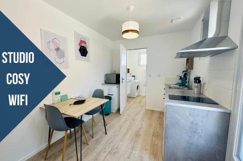 eine Küche mit einem Tisch und Stühlen im Zimmer in der Unterkunft Le cocon - 2 km de la plage in Saint-Vivien