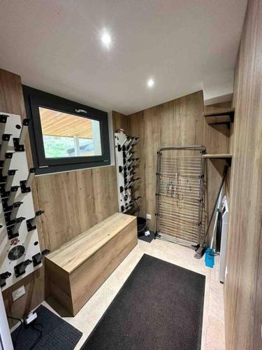 Cette chambre comprend un sauna avec une fenêtre et des bouteilles de vin. dans l'établissement Très bel appart avec vue 8 personnes Alpe d’Huez, à Huez
