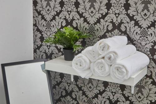 a stack of towels on a shelf in a bathroom at Stylish Comfortable Home With Parking in Redcar