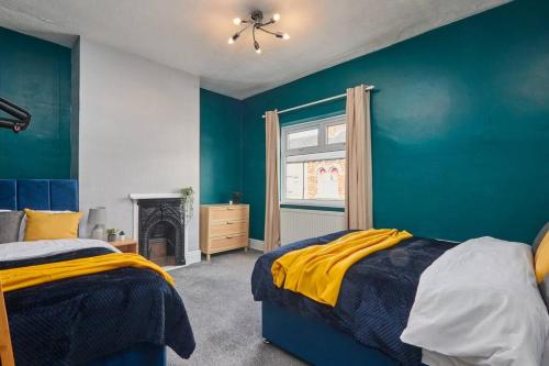 a blue bedroom with two beds and a fireplace at Stylish Comfortable Home With Parking in Redcar