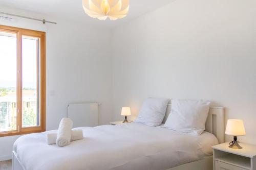 une chambre avec un grand lit blanc avec deux lampes dans l'établissement ZenBNB / Scandinavian / Gare / Parking Privé /, à Annemasse