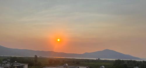 a sunset over a field with a mountain in the background at Villa Yseni in Orikum