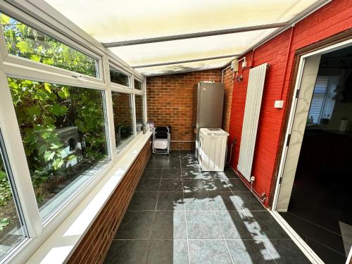 porche cerrado con ventanas y calefactor en Detached house in Essex, en Harlow