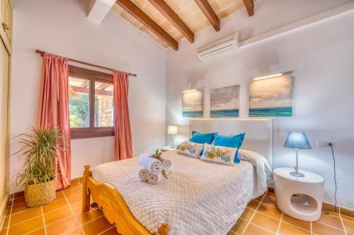 a bedroom with a bed with blue pillows at Ideal Property Mallorca - Rotes in El Port