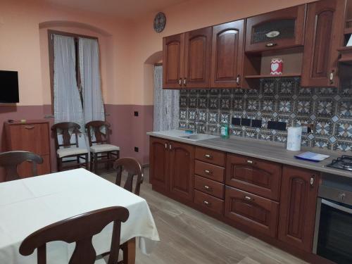 una cocina con armarios de madera, mesa y sillas en Albergo Jolanda en Diano Marina