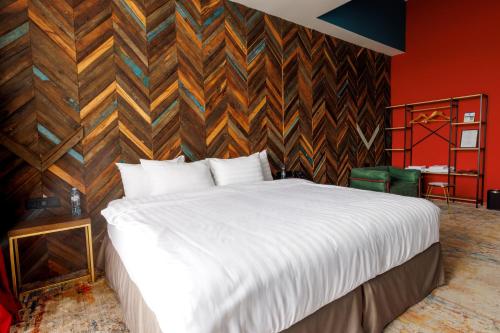 a bedroom with a white bed and a wooden wall at Mtserlebi Resort in K'vishkhet'i