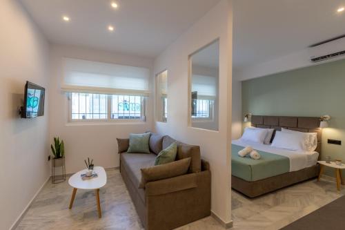 Mandevilia Suites في أثينا: غرفة معيشة مع سرير وأريكة
