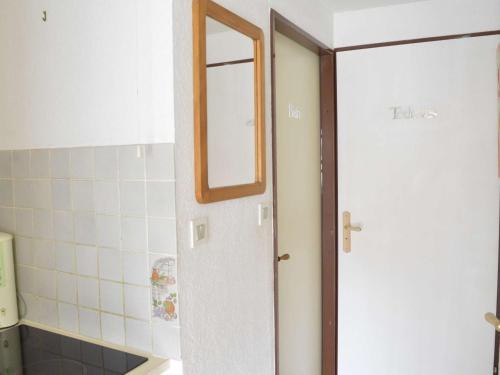 La salle de bains est pourvue d'un miroir et d'une porte blanche. dans l'établissement Appartement 2 pièces cabine, piscine, tennis, proche plage Richelieu, Cap d’Agde, 6 personnes - FR-1-249-87, au Cap d'Agde