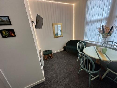 uma sala de estar com uma mesa e um sofá em Emerald Apartment Pleasure Beach Blackpool em Blackpool