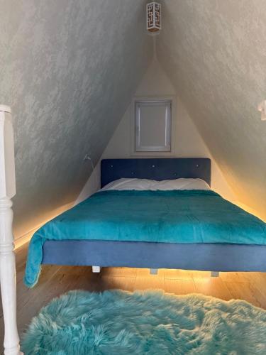 a bedroom with a blue bed in a attic at Афреем дом in Borovoye