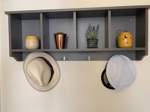 a shelf with hats and vases on a wall at Newly Renovated Flat with Free Parking in Walker Gate