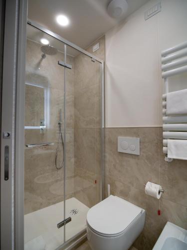 a bathroom with a toilet and a glass shower at Torre del Fuggisole in Siena