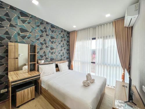 a bedroom with a bed with a teddy bear on it at Phattharasaya Home in Udon Thani