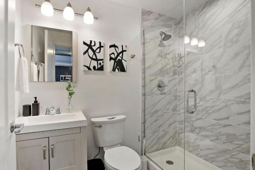 a bathroom with a shower and a toilet and a sink at 1BR Prime and Comfy Apt with In-Unit Laundry - Lake 302 in Chicago
