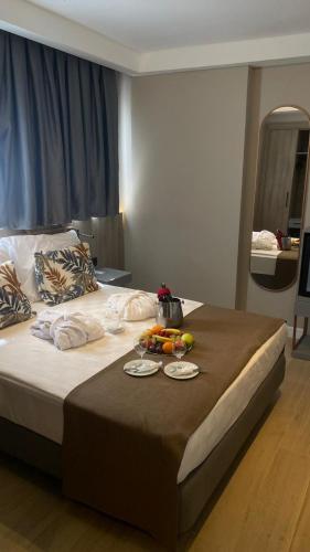 a bed with two plates of food on top of it at Alessia Hotel in Side