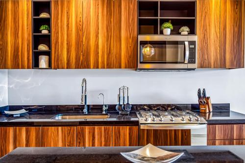 a kitchen with a stove and a microwave at D'Toscana Residencial # 305 in Nuevo Vallarta 