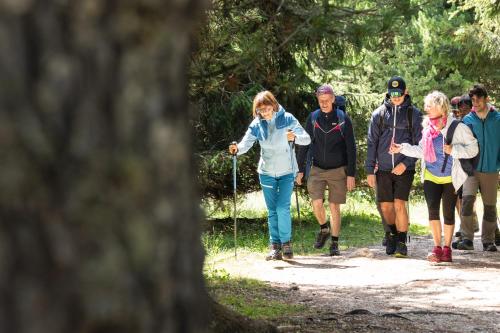 a group of people walking on a trail at Hotel Garden in Moena