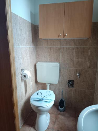 a bathroom with a white toilet and a cabinet at Naturnahe Ferienwohnung in Ruthenbeck