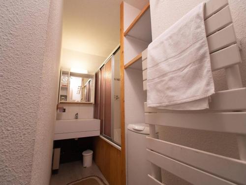 La salle de bains est pourvue d'un lavabo et d'une serviette blanche. dans l'établissement Appartement 3 pièces 8 pers, balcon, animaux acceptés - FR-1-291-759, à Valmorel