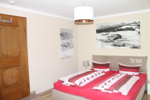 a bedroom with a bed with red and white pillows at Winklmoos Sonnenalm in Reit im Winkl