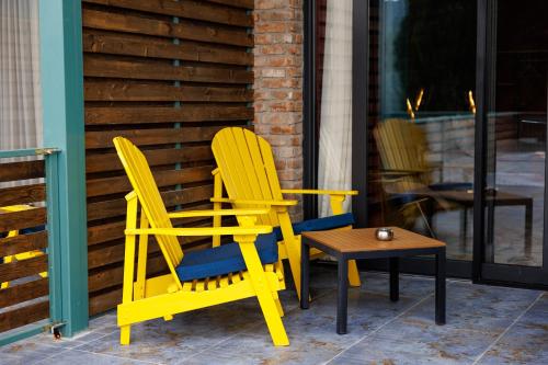 two yellow chairs and a table on a patio at Mtserlebi Resort in K'vishkhet'i