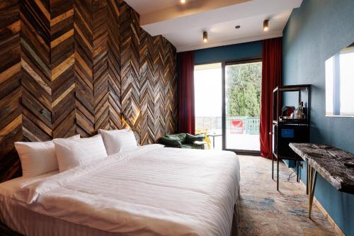 a bedroom with a large bed with a wooden wall at Mtserlebi Resort in K'vishkhet'i