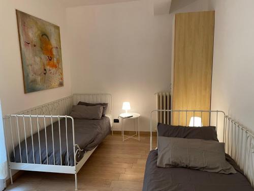 um quarto com duas camas e um quadro na parede em Residenza Santo Stefano 95 - Santo Stefano apartment em Bolonha