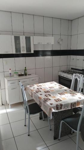 kuchnia ze stołem, krzesłami i kuchenką w obiekcie Apt vista panorâmica w mieście Triunfo