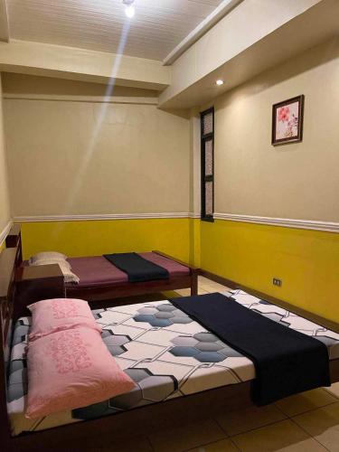 a room with two beds in the corner of a room at ASHBURN'S TRANSIENT BAGUIO - 3rd to 5th floor BASIC SLEEP and GO Accommodation, WITH PARKING, NO ELEVATOR in Baguio