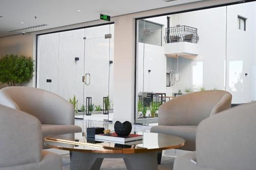 ein Wohnzimmer mit 2 Stühlen und einem Couchtisch in der Unterkunft بوابة النخيل للشقق الفندقية in Riad