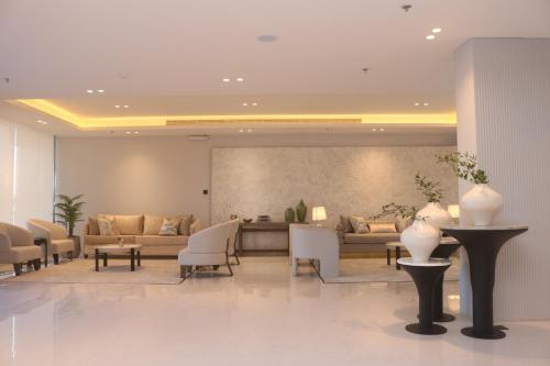 un vestíbulo con sofás, mesas y sillas en بوابة النخيل للشقق الفندقية, en Riad