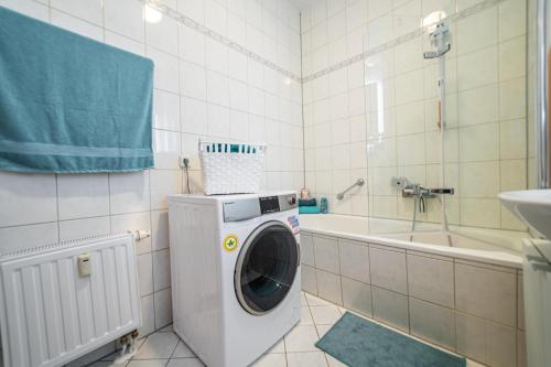 a washing machine in a bathroom with a tub at FullHouse - Leonardo Apt - 3 Bedrooms & Balcony in Chemnitz