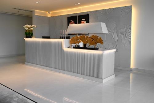 a lobby with a white counter with plants on it at Bawabat Alnakhil For Hotel Apartments in Riyadh