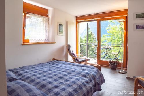 a bedroom with a bed and a large window at Appartamenti Bertazzi in Cavagnago