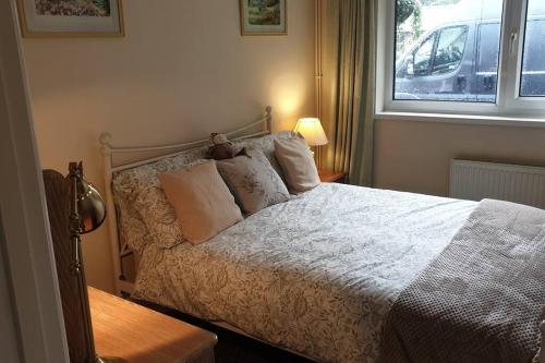 um quarto com uma cama branca e uma janela em Chestnut Lodge Annex em Bridgend