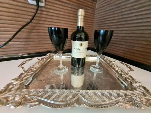 a bottle of wine and two wine glasses on a tray at GUEST HOUSE in VERGIA in Vergia