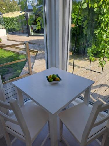 a white table with two chairs and a bowl of fruit at Harmony in Farhult in Farhult