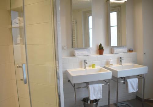 une salle de bain avec deux lavabos et une douche dans l'établissement Artist - Montparnasse, à Paris