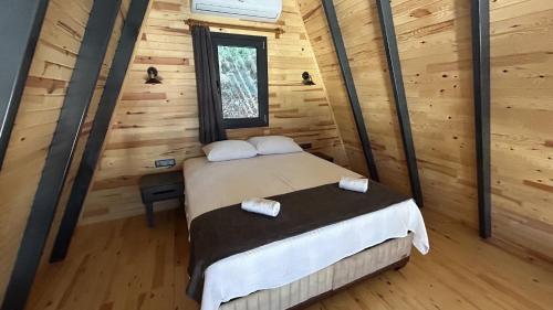 ein Schlafzimmer mit einem Bett in einem Blockhaus in der Unterkunft Ay-Ra Bungalow Suite in Kaş