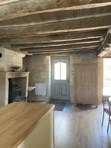 a large room with a kitchen with a table and a door at Gite des vieilles pierres in Seigy