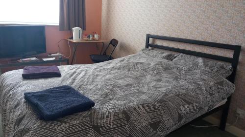 a bedroom with a bed with two towels on it at Lesley House in Bridgwater