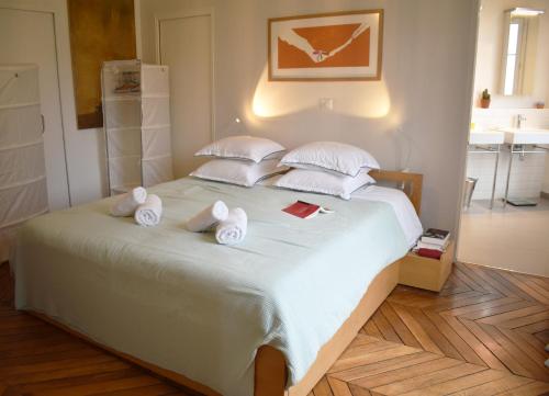 une chambre avec un grand lit avec des serviettes dessus dans l'établissement Artist - Montparnasse, à Paris