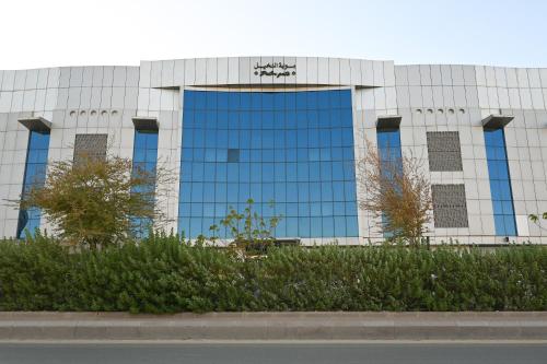 a tall glass building with blue windows on it at Bawabat Alnakhil For Hotel Apartments in Riyadh