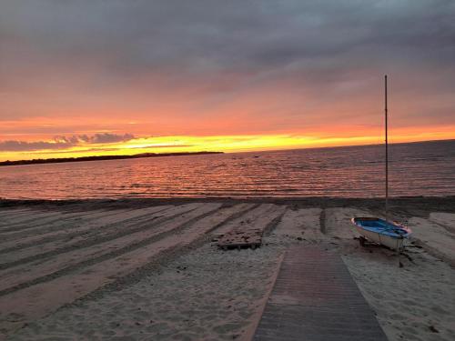a bench on the beach with a sunset in the background at Harmony in Farhult in Farhult