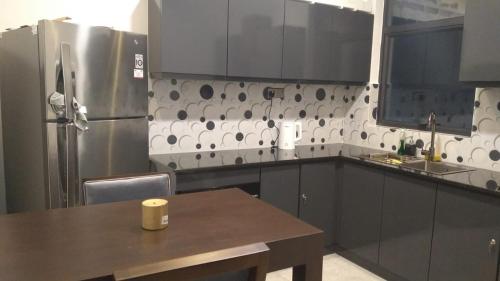 a kitchen with a table and a stainless steel refrigerator at MercuryFM 105 House Colombo 3 - Schofield pl 3-2 in Colombo